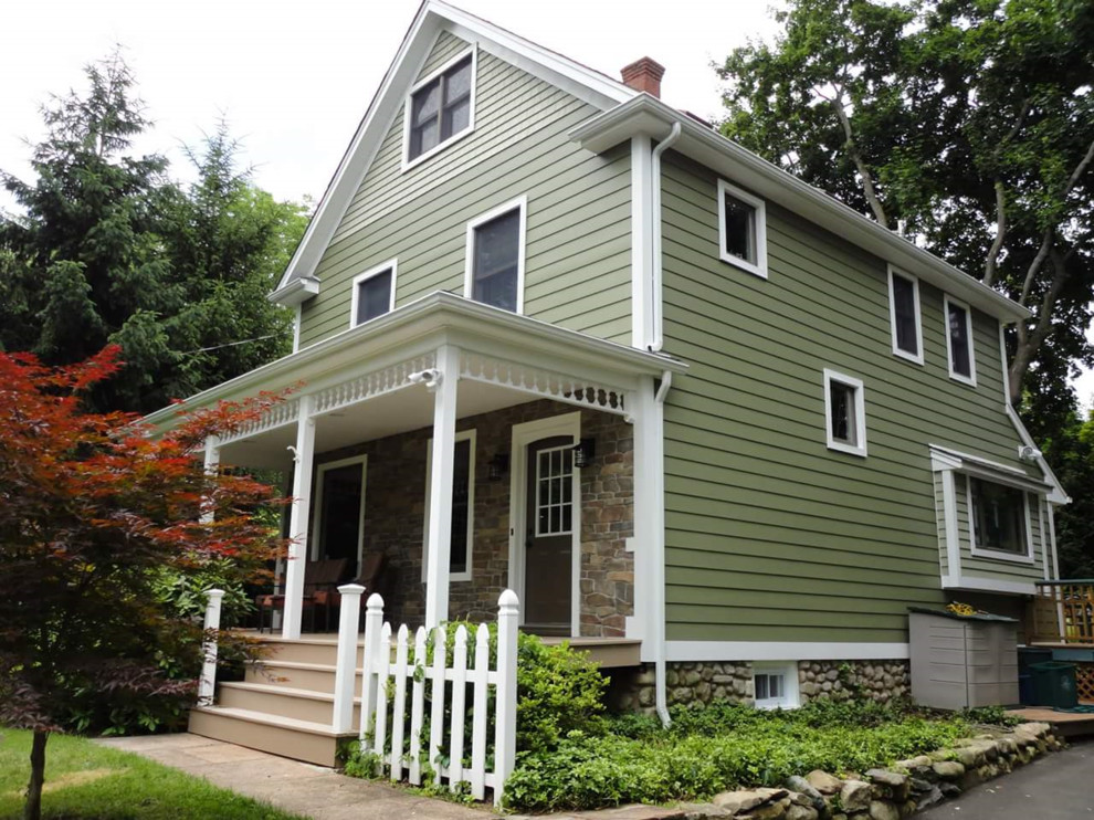 Photo of a mid-sized traditional three-storey green exterior in Austin with vinyl siding and a gable roof.