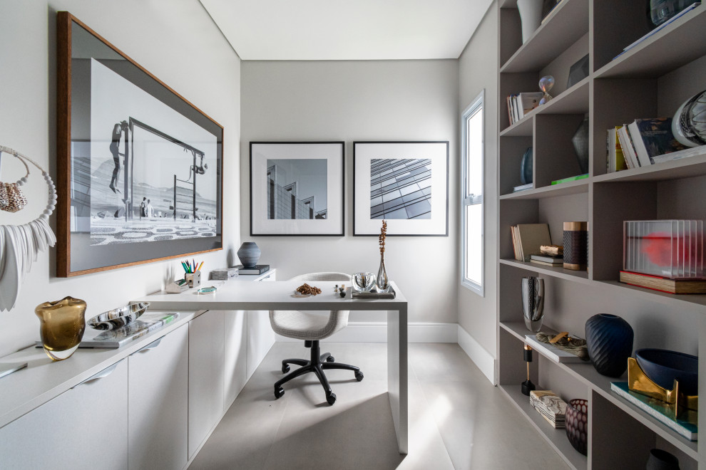 Photo of a contemporary home office in Miami with grey walls, a built-in desk and grey floor.