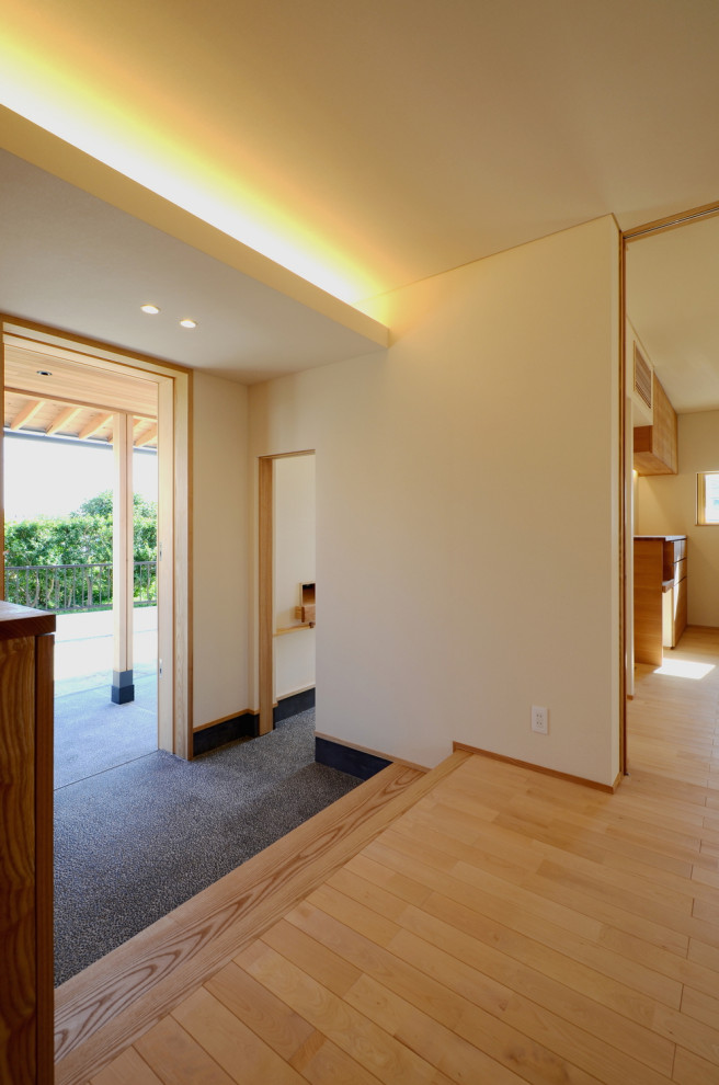 Aménagement d'une entrée de taille moyenne avec un couloir, un mur blanc, parquet clair, une porte coulissante, une porte en bois foncé, un sol marron, un plafond en papier peint et du papier peint.