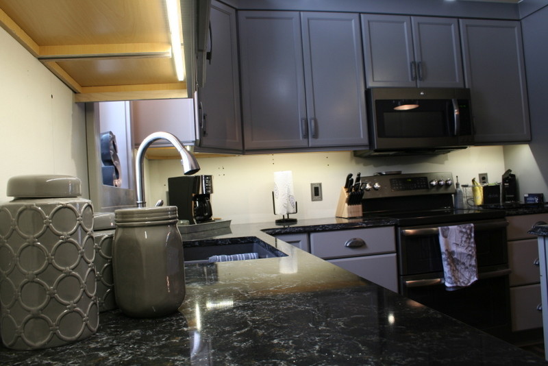 Inspiration for a small transitional l-shaped vinyl floor enclosed kitchen remodel with a double-bowl sink, flat-panel cabinets, gray cabinets, quartz countertops, stainless steel appliances and an island