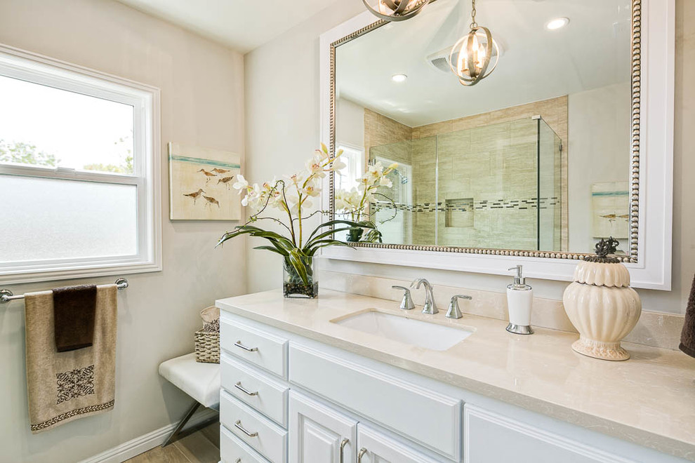 Inspiration for an expansive transitional master bathroom in Los Angeles with shaker cabinets, white cabinets, a freestanding tub, an alcove shower, a one-piece toilet, beige walls, marble floors, a drop-in sink, engineered quartz benchtops, beige floor and a hinged shower door.
