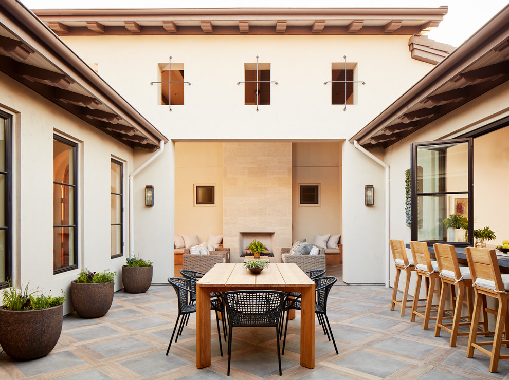 Inspiration for a mid-sized mediterranean courtyard patio in San Francisco with a roof extension, concrete pavers and with fireplace.
