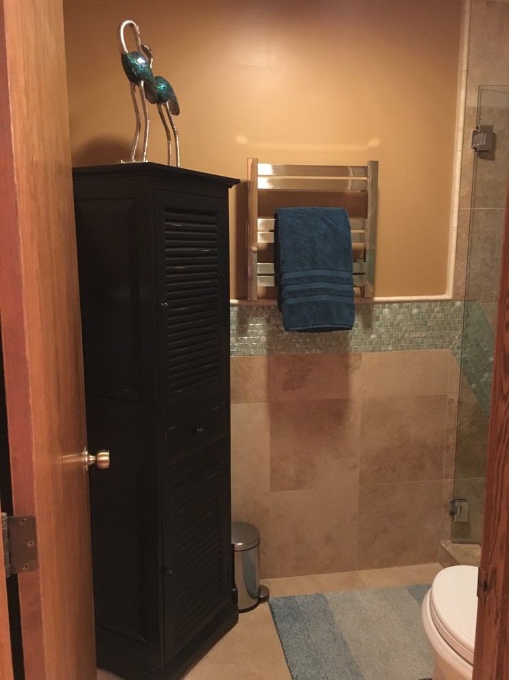 Mid-sized mediterranean 3/4 bathroom in Other with raised-panel cabinets, brown cabinets, an alcove shower, a two-piece toilet, green tile, glass tile, orange walls, travertine floors, an undermount sink, engineered quartz benchtops, beige floor and a hinged shower door.