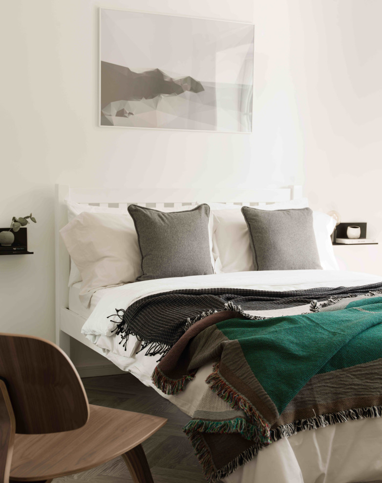 Ejemplo de habitación de invitados escandinava con paredes blancas y suelo laminado