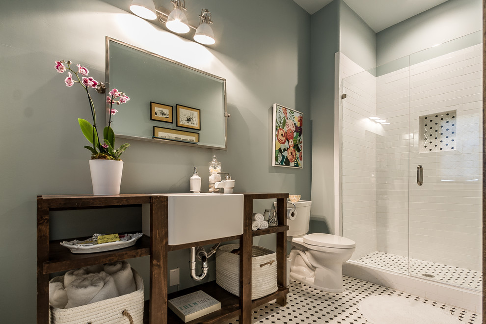This is an example of a country bathroom in Dallas with open cabinets, brown cabinets, a one-piece toilet, white tile, ceramic tile, blue walls, mosaic tile floors, wood benchtops, white floor, a hinged shower door, brown benchtops, a single vanity and a freestanding vanity.