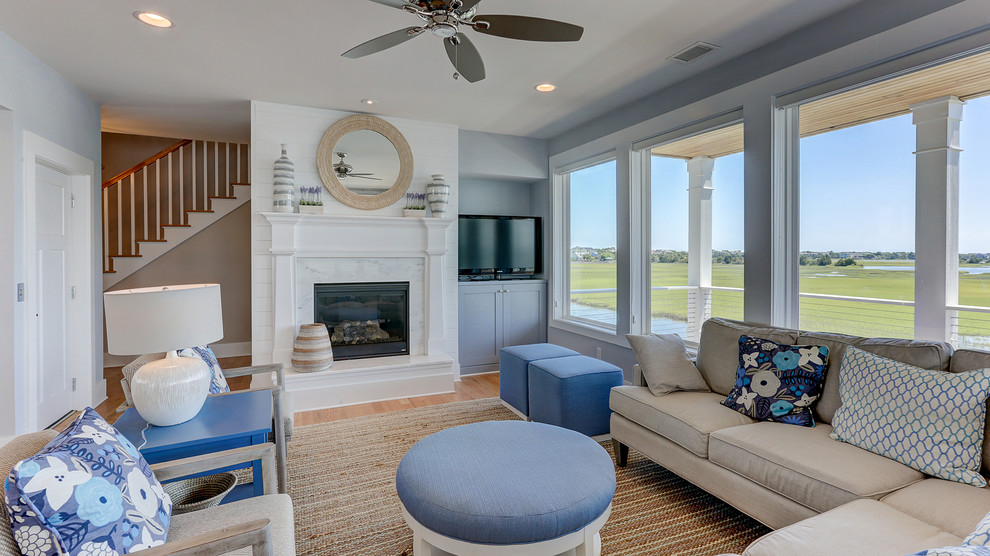 Beach style living room in Other with blue walls and light hardwood floors.