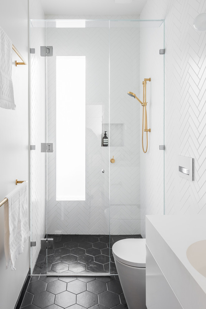 Inspiration for a small contemporary 3/4 bathroom in Melbourne with flat-panel cabinets, white cabinets, an alcove shower, a one-piece toilet, white tile, ceramic tile, white walls, porcelain floors, an integrated sink, solid surface benchtops, black floor and a hinged shower door.