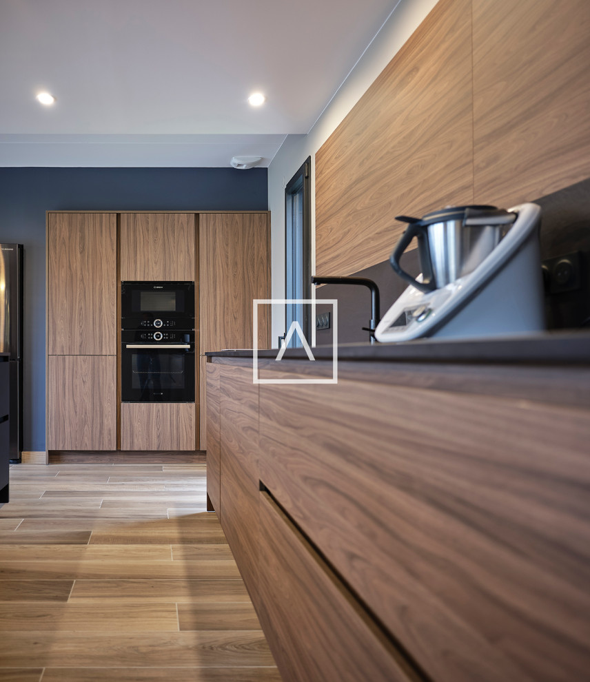 Large contemporary kitchen in Toulouse with flat-panel cabinets, dark wood cabinets, composite countertops, black splashback, an island and black worktops.