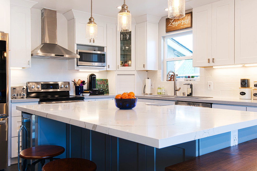 Photo of a large modern u-shaped eat-in kitchen in San Francisco with an undermount sink, shaker cabinets, white cabinets, marble benchtops, white splashback, ceramic splashback, stainless steel appliances, slate floors, with island, black floor and white benchtop.