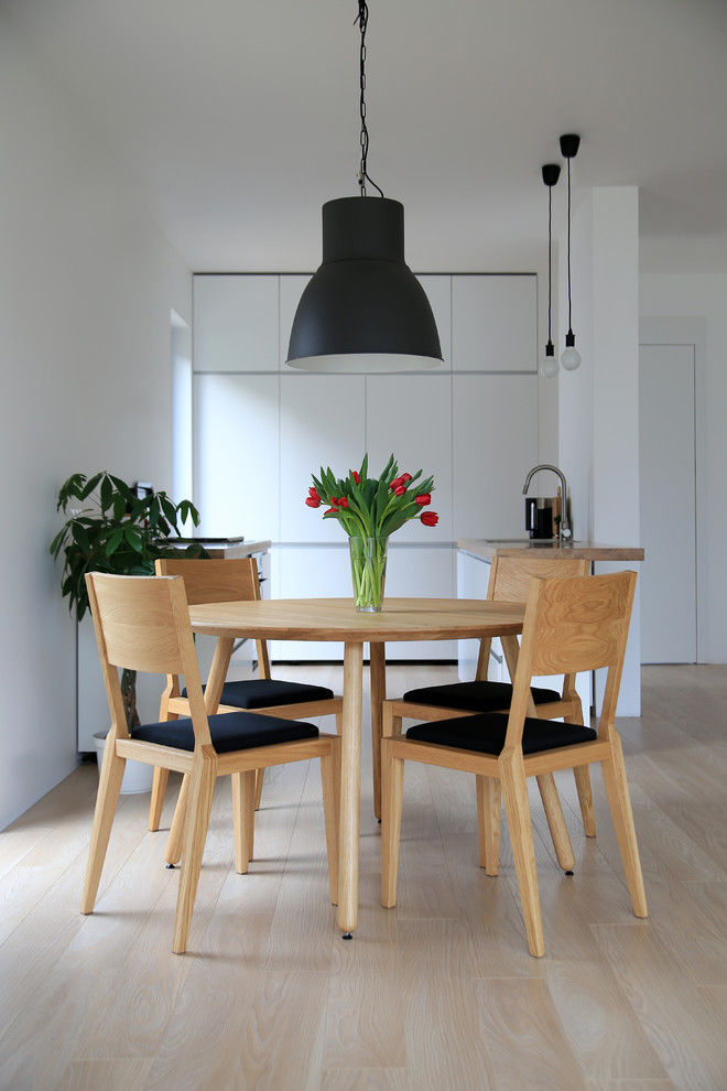 This is an example of a mid-sized contemporary open plan dining in Other with white walls, light hardwood floors and no fireplace.