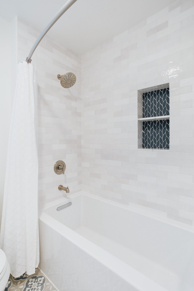 На фото: детская ванная комната среднего размера в морском стиле с фасадами в стиле шейкер, белыми фасадами, ванной в нише, душем в нише, раздельным унитазом, серой плиткой, стеклянной плиткой, белыми стенами, полом из керамогранита, врезной раковиной, столешницей из искусственного кварца, разноцветным полом, шторкой для ванной, белой столешницей, нишей, тумбой под две раковины и встроенной тумбой