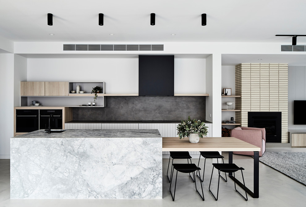 Large contemporary galley kitchen in Sydney with an undermount sink, white cabinets, marble benchtops, grey splashback, porcelain splashback, with island and grey benchtop.