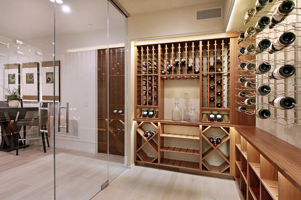 This is an example of a mid-sized contemporary wine cellar in Orange County with light hardwood floors, storage racks and brown floor.