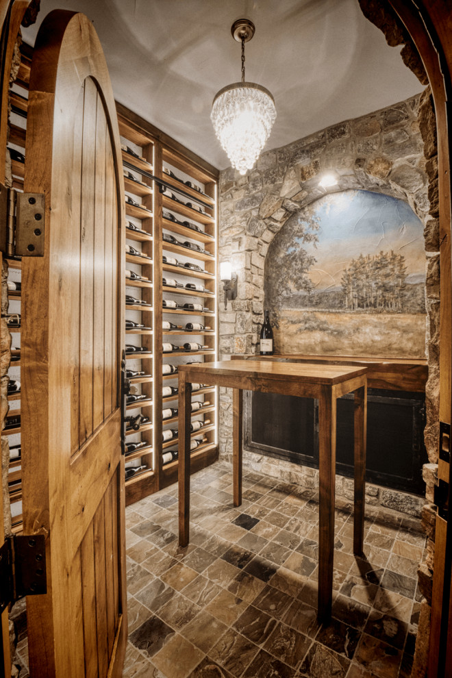 Aménagement d'une cave à vin méditerranéenne de taille moyenne avec un sol en carrelage de porcelaine, un présentoir et un sol marron.