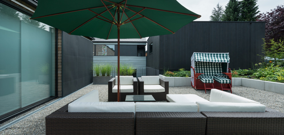 This is an example of an expansive contemporary backyard deck in Other with no cover and a container garden.
