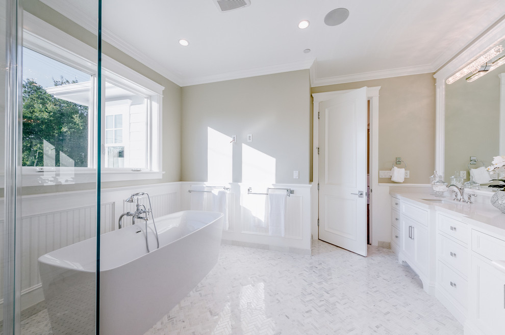 Design ideas for a large transitional master wet room bathroom in Los Angeles with white cabinets, a freestanding tub, a two-piece toilet, beige walls, an undermount sink, solid surface benchtops, a hinged shower door and recessed-panel cabinets.