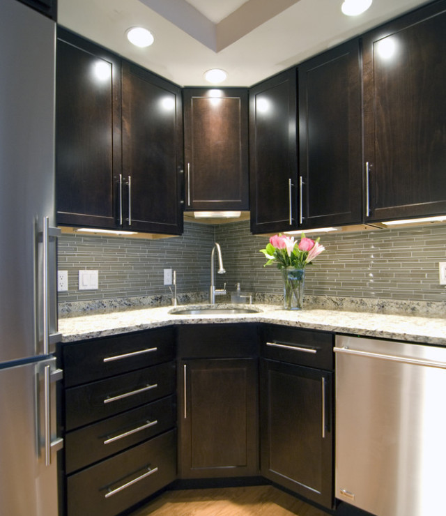 Mid-sized tuscan l-shaped medium tone wood floor and brown floor kitchen photo in Austin with an undermount sink, shaker cabinets, dark wood cabinets, granite countertops, green backsplash, matchstick tile backsplash, stainless steel appliances and no island