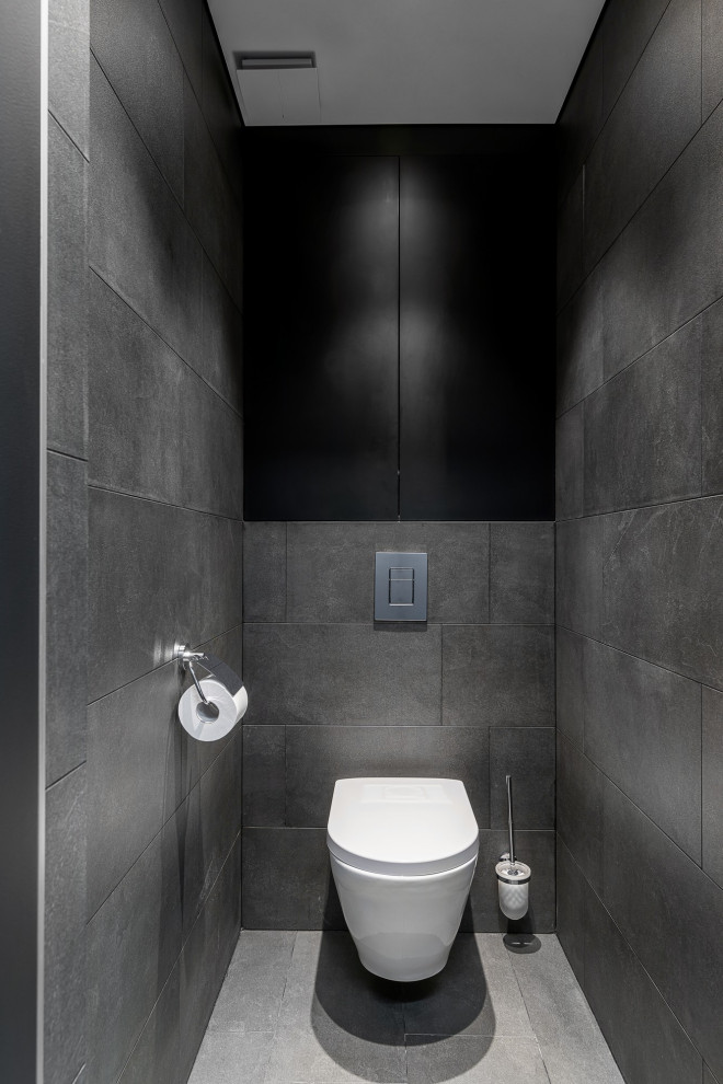 Свежая идея для дизайна: туалет среднего размера в современном стиле с серыми стенами, плоскими фасадами, серыми фасадами, инсталляцией, серой плиткой, керамогранитной плиткой, полом из керамогранита, серым полом и панелями на части стены - отличное фото интерьера