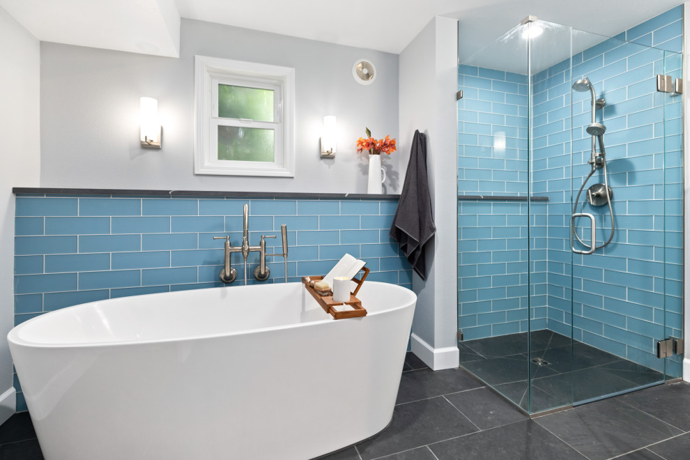 This is an example of a medium sized contemporary ensuite bathroom in Other with black cabinets, a freestanding bath, a built-in shower, blue tiles, glass tiles, white walls, slate flooring, a submerged sink, engineered stone worktops, black floors, black worktops and a built in vanity unit.