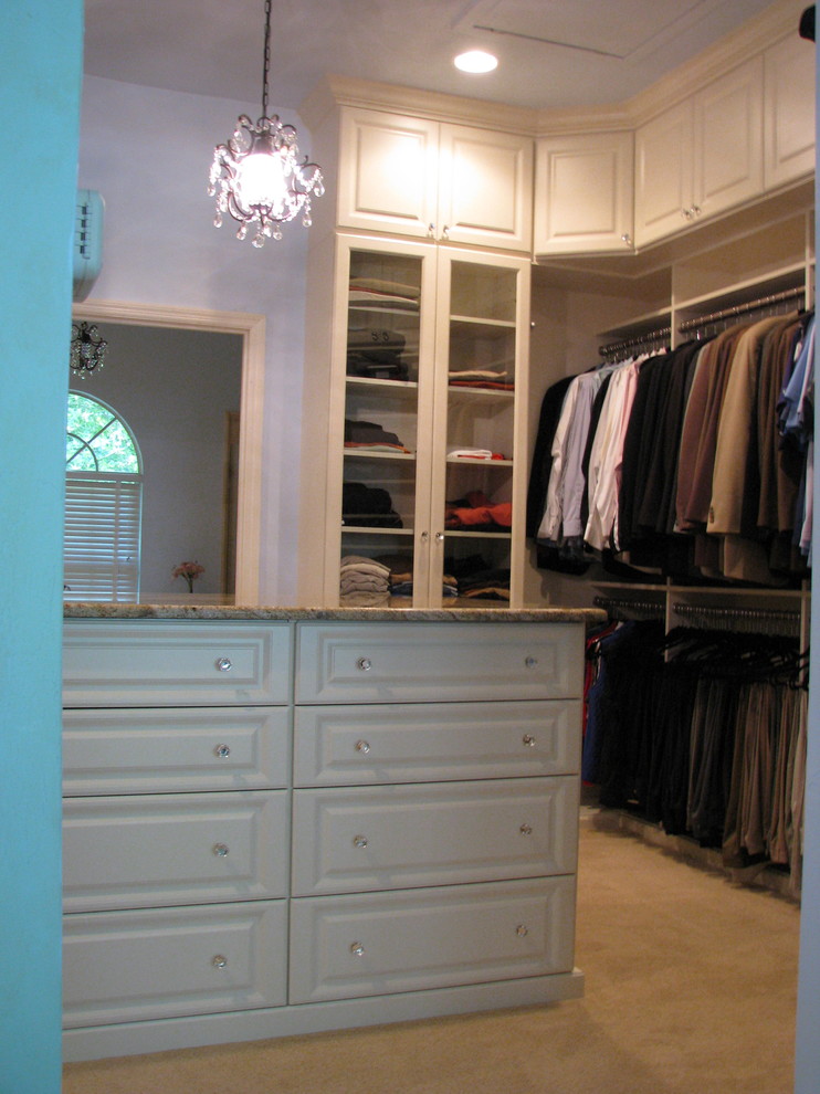 Large traditional gender-neutral walk-in wardrobe in Miami with raised-panel cabinets, white cabinets, carpet and beige floor.