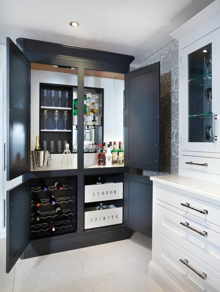 This is an example of a mid-sized traditional single-wall home bar in Belfast with an undermount sink, shaker cabinets, grey cabinets, quartzite benchtops, black splashback, porcelain floors and grey floor.