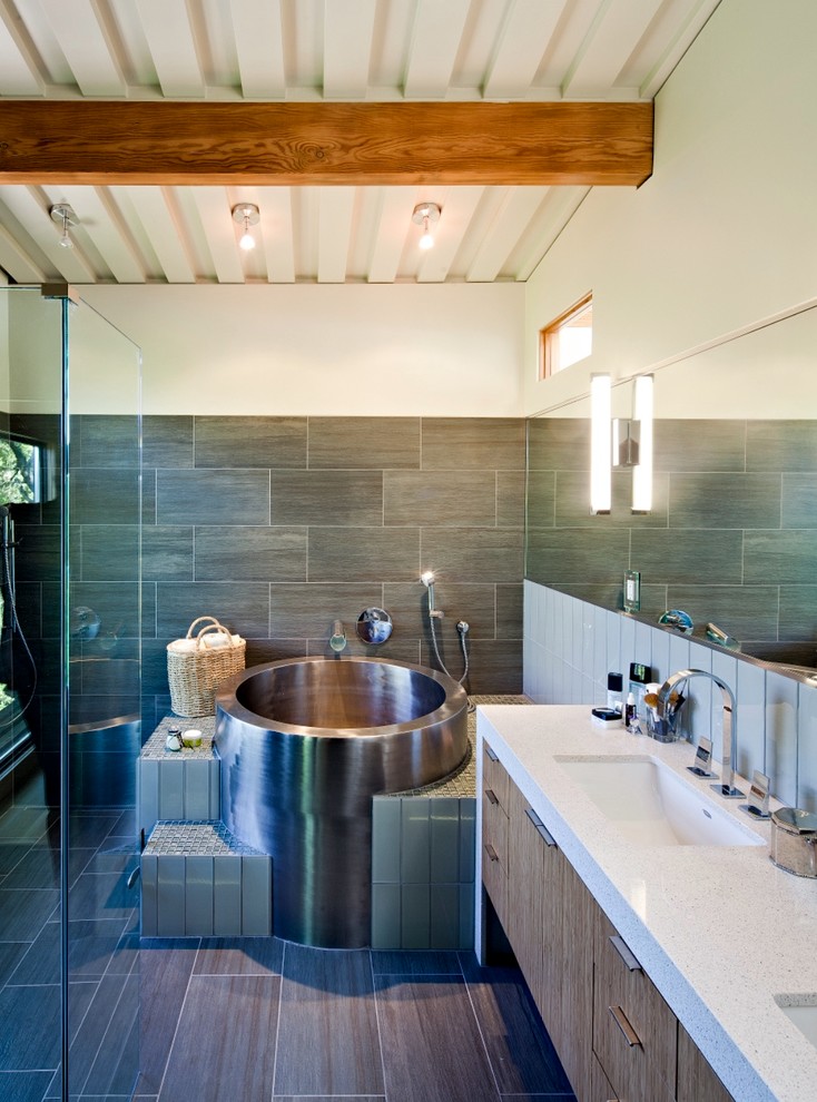 Photo of a contemporary bathroom in San Francisco with flat-panel cabinets, a japanese tub and white benchtops.