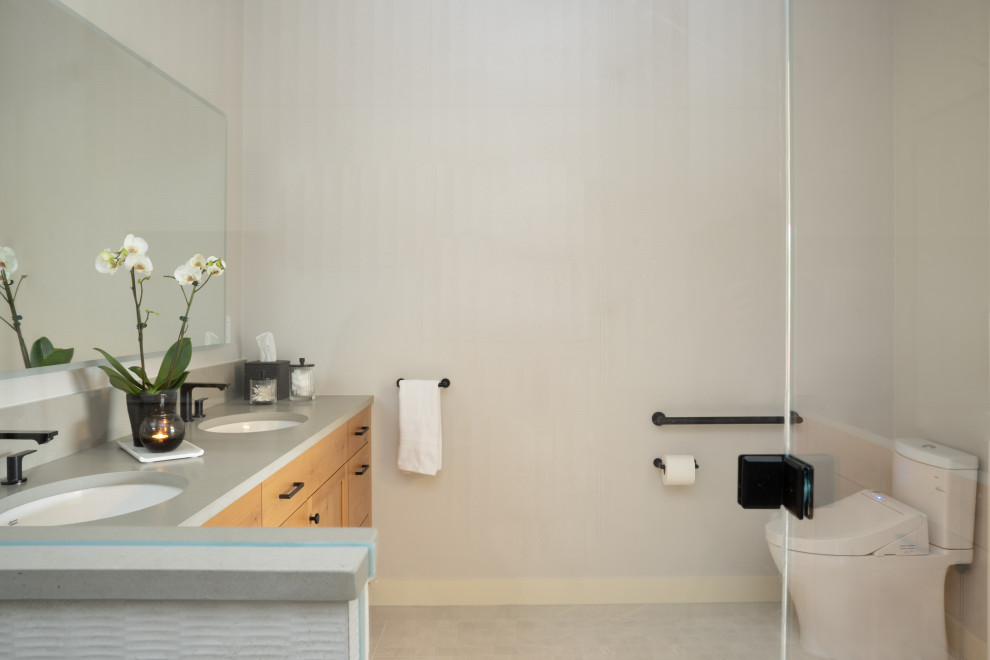 Inspiration for a medium sized modern ensuite bathroom in Portland with recessed-panel cabinets, medium wood cabinets, a built-in shower, a one-piece toilet, beige tiles, ceramic tiles, black walls, ceramic flooring, a built-in sink, quartz worktops, beige floors, a hinged door, grey worktops, a wall niche, double sinks and a built in vanity unit.
