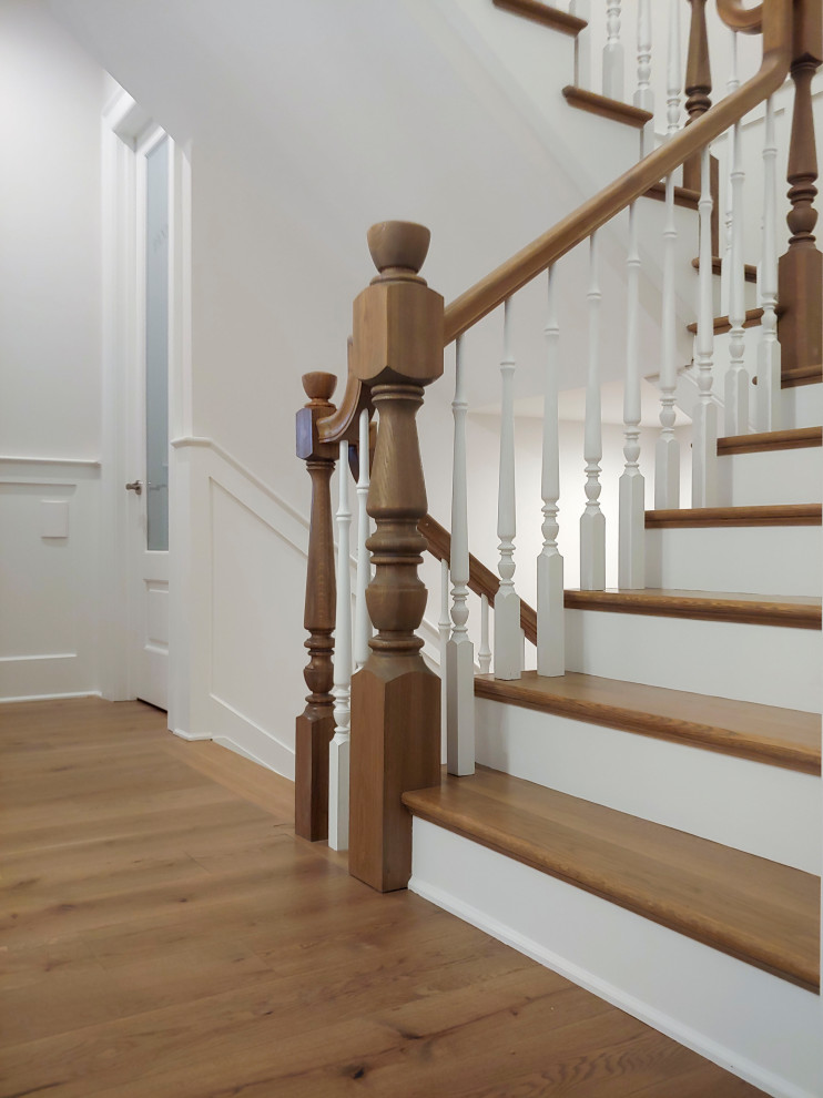 Inspiration for a mid-sized traditional wood u-shaped staircase in DC Metro with painted wood risers, wood railing and decorative wall panelling.