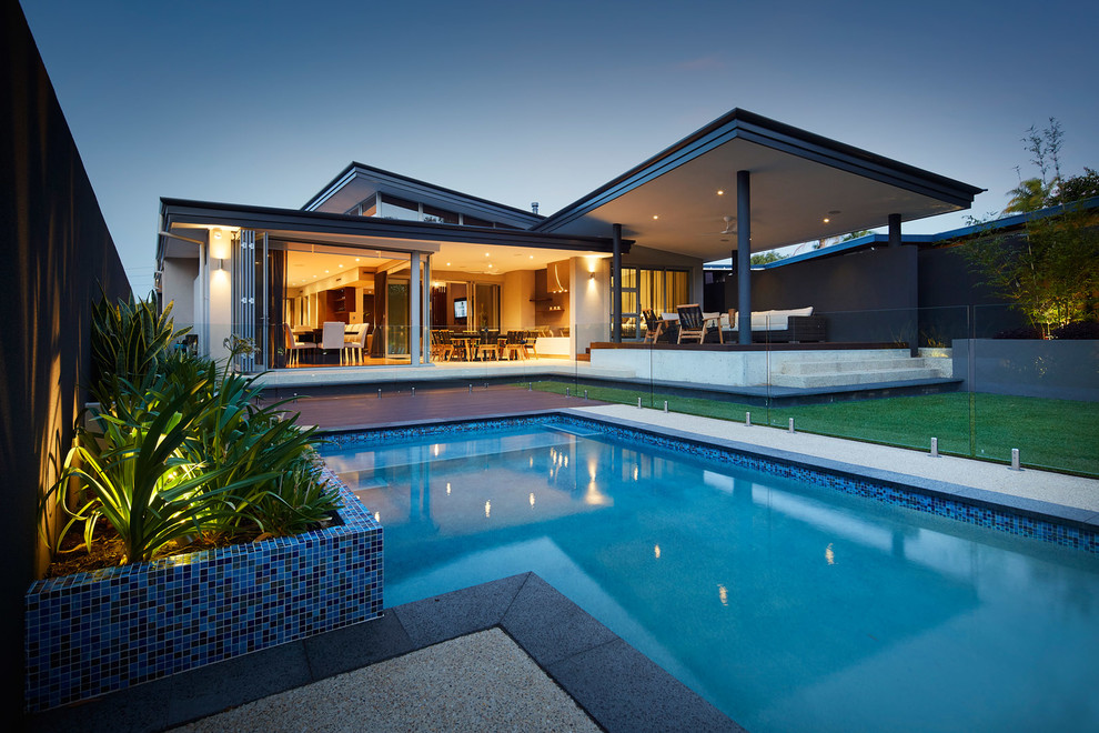 Photo of a mid-sized contemporary backyard custom-shaped natural pool in Other with concrete slab.