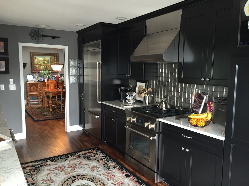 Inspiration for a small transitional galley eat-in kitchen in Seattle with recessed-panel cabinets, black cabinets, marble benchtops, metallic splashback, metal splashback, stainless steel appliances, no island, an undermount sink, medium hardwood floors and brown floor.