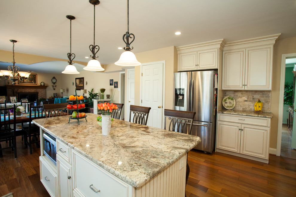 Kitchen - traditional kitchen idea in Wilmington with an undermount sink, raised-panel cabinets, wood countertops, stainless steel appliances and an island
