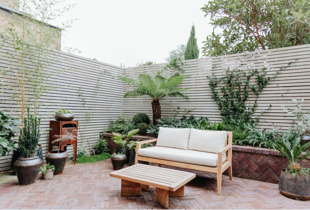 Ispirazione per un piccolo patio o portico minimalista dietro casa con pavimentazioni in mattoni