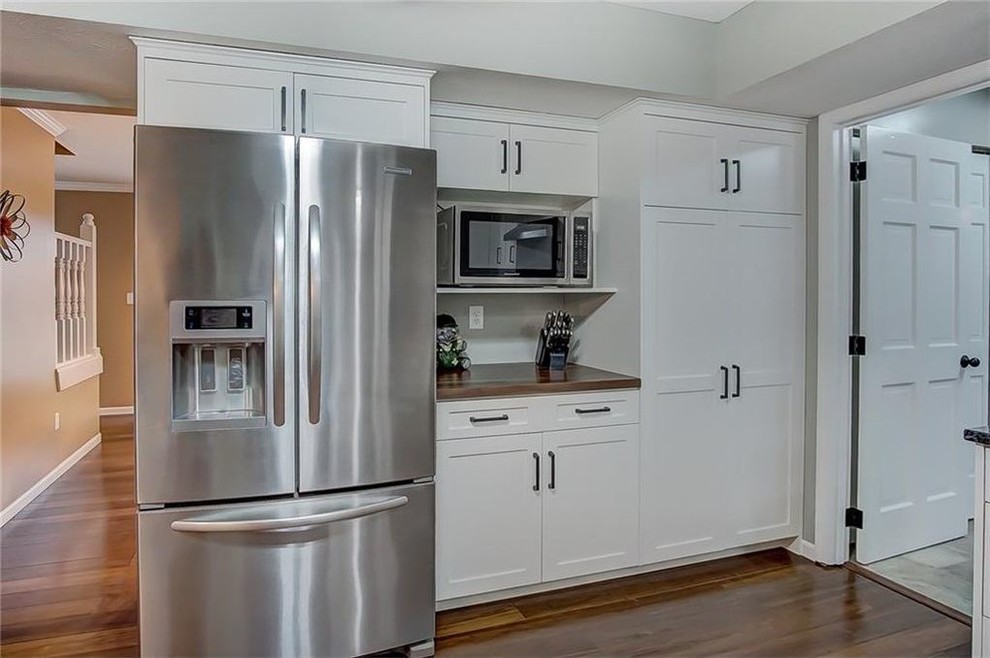 Transitional medium tone wood floor kitchen photo with shaker cabinets, white cabinets and granite countertops
