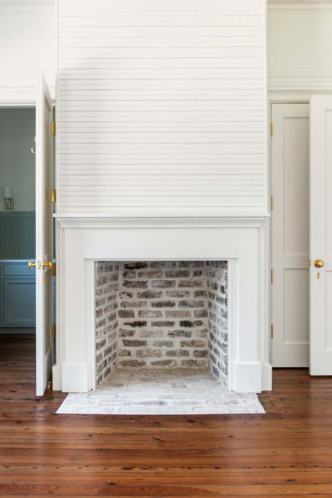 チャールストンにあるトラディショナルスタイルのおしゃれな客用寝室 (白い壁、無垢フローリング、標準型暖炉、木材の暖炉まわり、板張り天井、板張り壁) のレイアウト