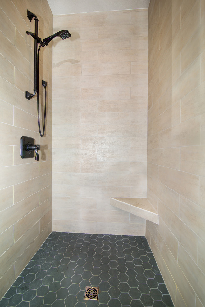 This is an example of a mid-sized transitional master bathroom in Denver with raised-panel cabinets, medium wood cabinets, a freestanding tub, a corner shower, beige tile, porcelain tile, multi-coloured walls, porcelain floors, an undermount sink, granite benchtops, grey floor and a hinged shower door.