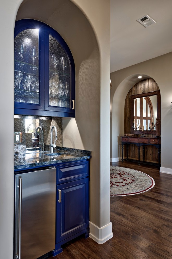 Inspiration for a small transitional single-wall wet bar in Austin with an undermount sink, raised-panel cabinets, blue cabinets, granite benchtops, dark hardwood floors, blue benchtop and brown splashback.