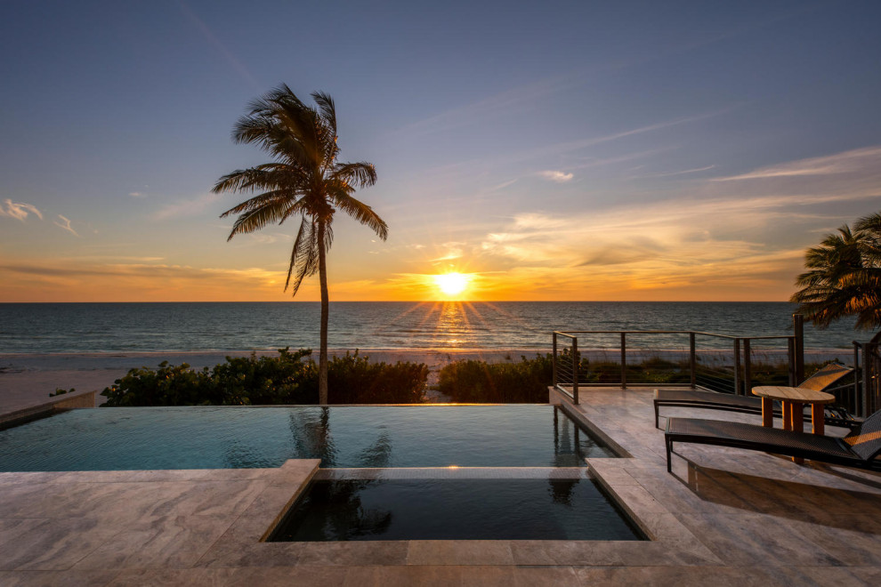 Design ideas for a large contemporary backyard rectangular infinity pool in Miami with a hot tub and tile.