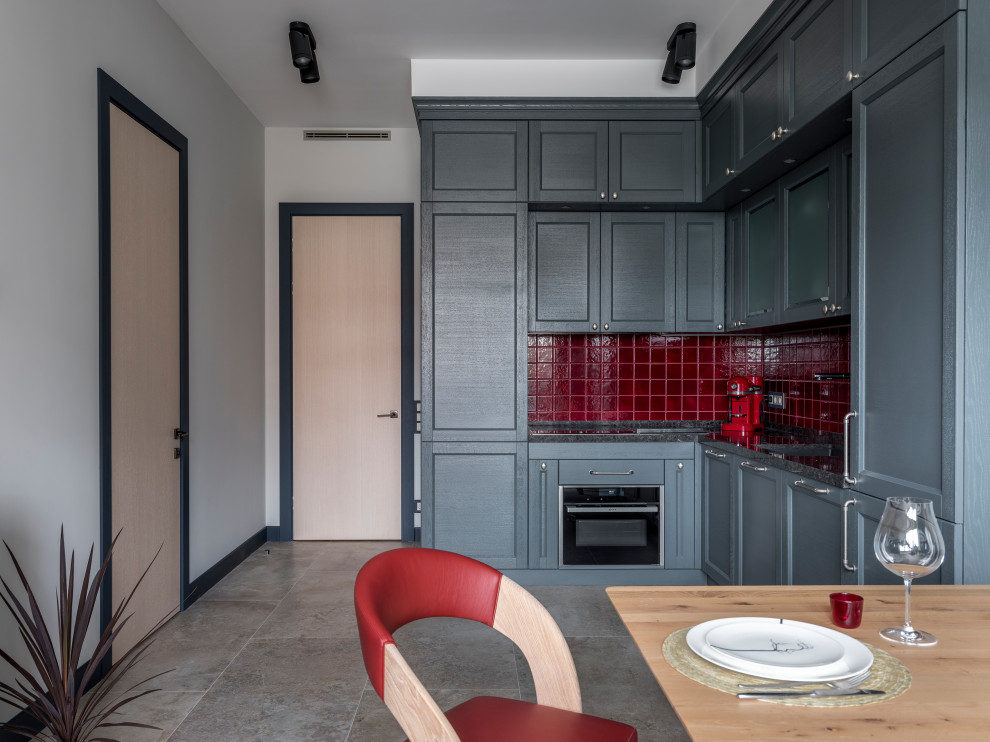 Inredning av ett modernt mellanstort grå grått kök, med luckor med infälld panel, grå skåp, bänkskiva i kvarts, rött stänkskydd, stänkskydd i keramik, klinkergolv i porslin och beiget golv