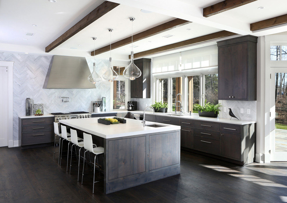 This is an example of an expansive contemporary l-shaped eat-in kitchen in New York with a farmhouse sink, recessed-panel cabinets, dark wood cabinets, quartz benchtops, white splashback, marble splashback, stainless steel appliances, dark hardwood floors, with island and brown floor.