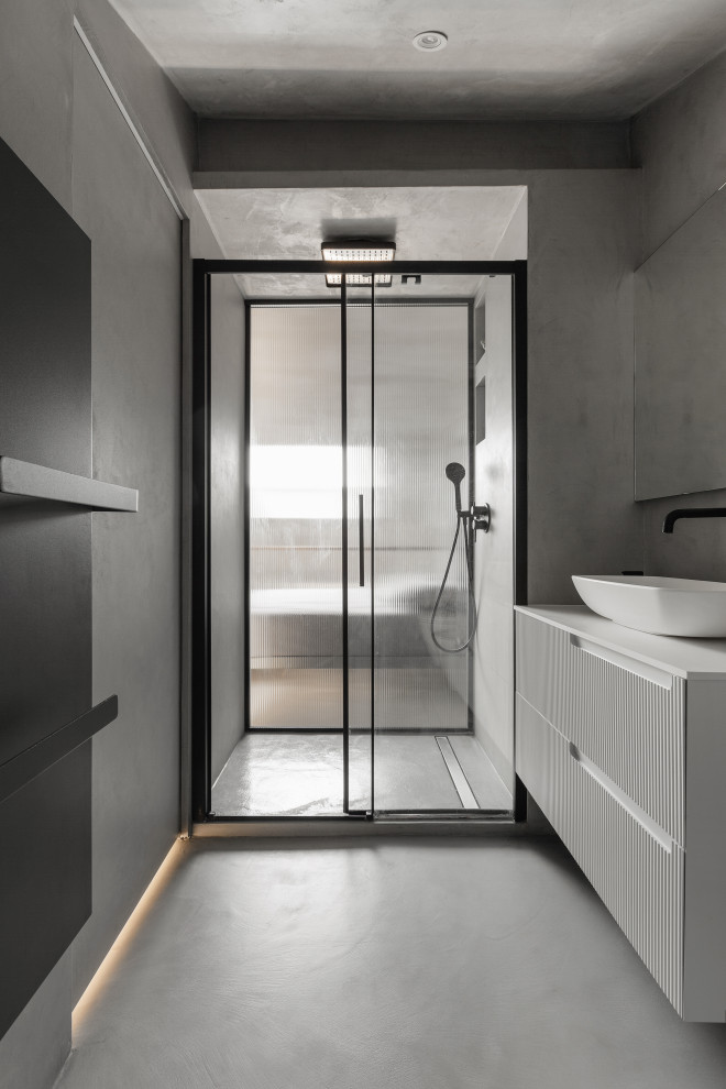 This is an example of a mid-sized scandinavian 3/4 bathroom in Milan with white cabinets, a single vanity, a floating vanity, grey walls, concrete floors, a vessel sink, grey floor, a sliding shower screen, white benchtops and recessed.