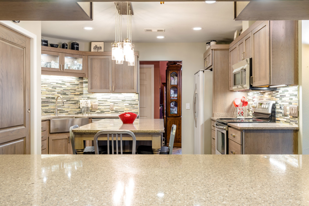 Mid-sized transitional u-shaped medium tone wood floor enclosed kitchen photo in Miami with a farmhouse sink, shaker cabinets, gray cabinets, quartz countertops, gray backsplash, glass tile backsplash, white appliances and an island