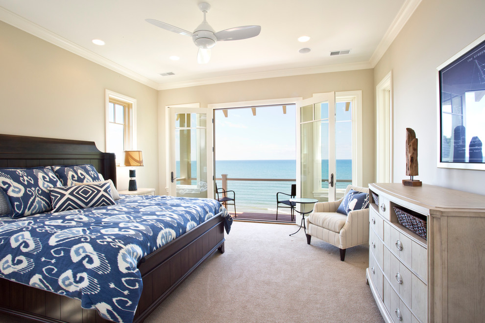 Photo of a large beach style master bedroom in Grand Rapids with beige walls and carpet.