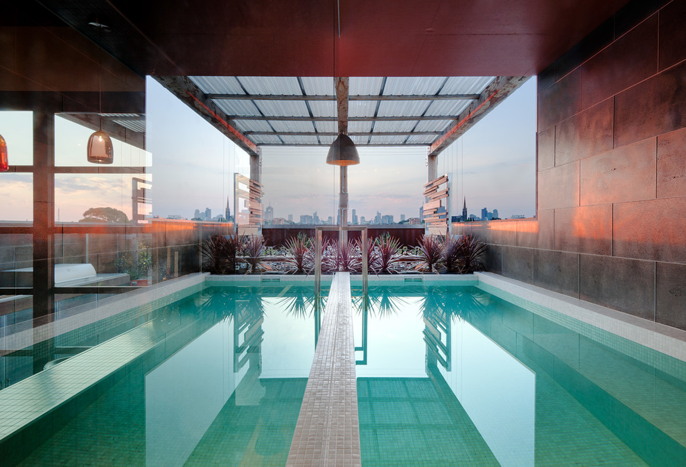 Photo of a contemporary rooftop rectangular lap pool in Other with tile.