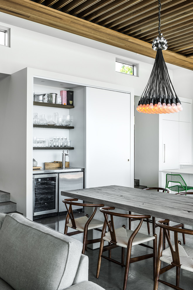 Contemporary open plan dining in Vancouver with white walls and concrete floors.