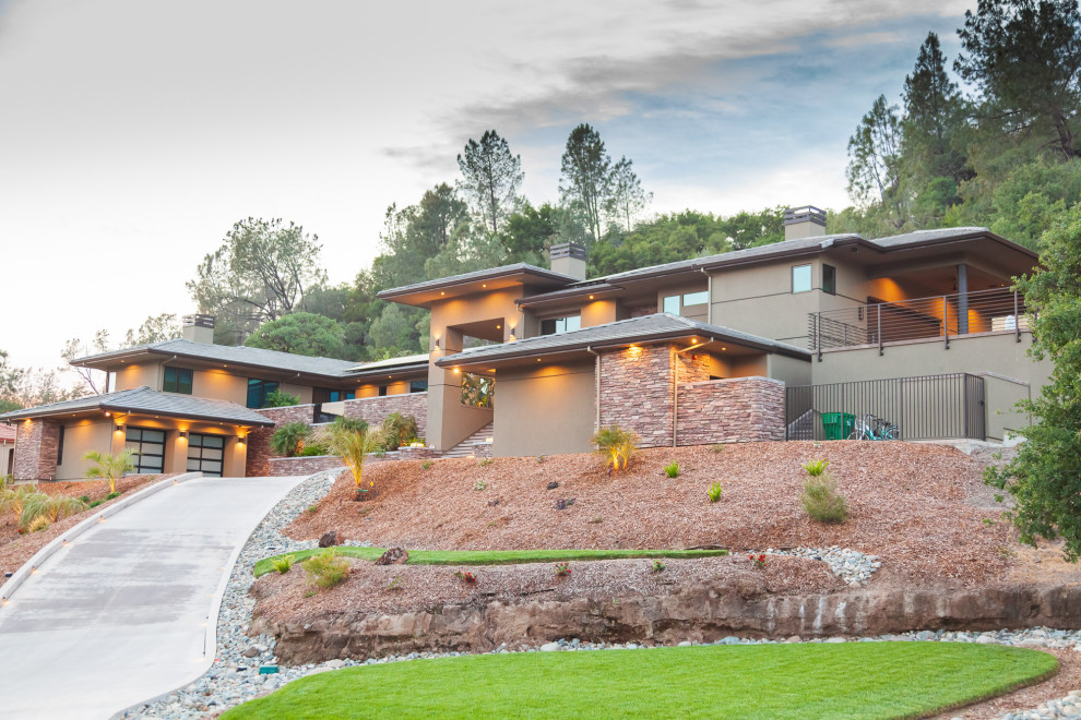 Inspiration for a large green split-level stucco house exterior remodel with a hip roof and a tile roof
