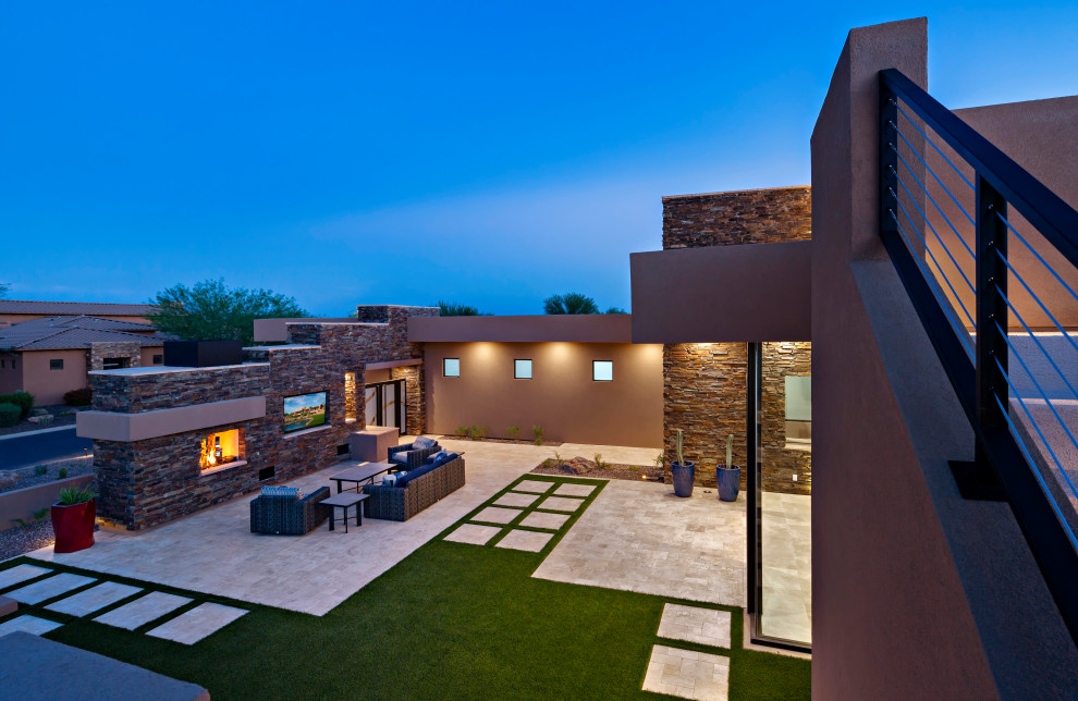 Inspiration for an expansive modern back patio in Phoenix with a fireplace and a roof extension.