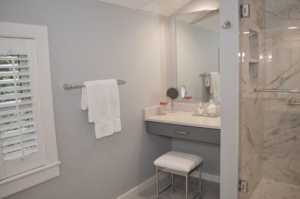 This is an example of a mid-sized transitional master bathroom in Cleveland with beaded inset cabinets, blue cabinets, a corner shower, a two-piece toilet, gray tile, porcelain tile, grey walls, mosaic tile floors, an undermount sink, engineered quartz benchtops, multi-coloured floor and a hinged shower door.