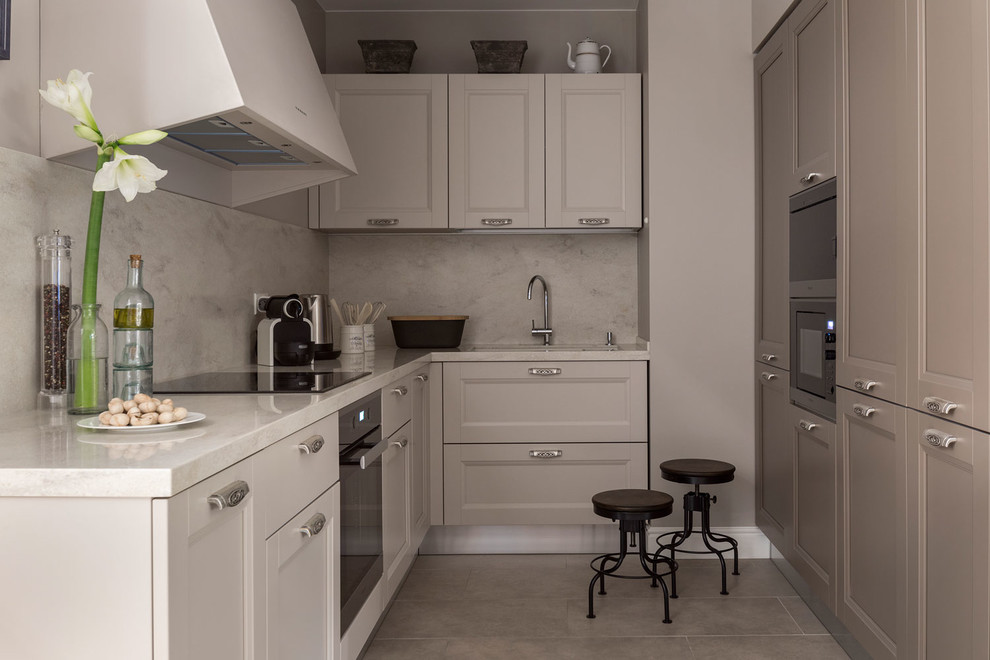 Inspiration for a mid-sized traditional l-shaped separate kitchen in Moscow with solid surface benchtops, porcelain floors, no island, black appliances, grey floor, an undermount sink, recessed-panel cabinets, brown cabinets and white splashback.
