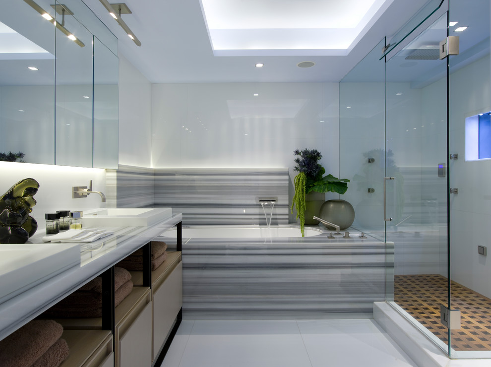 This is an example of a contemporary bathroom in Miami with open cabinets, an undermount tub, a corner shower, white walls and gray tile.