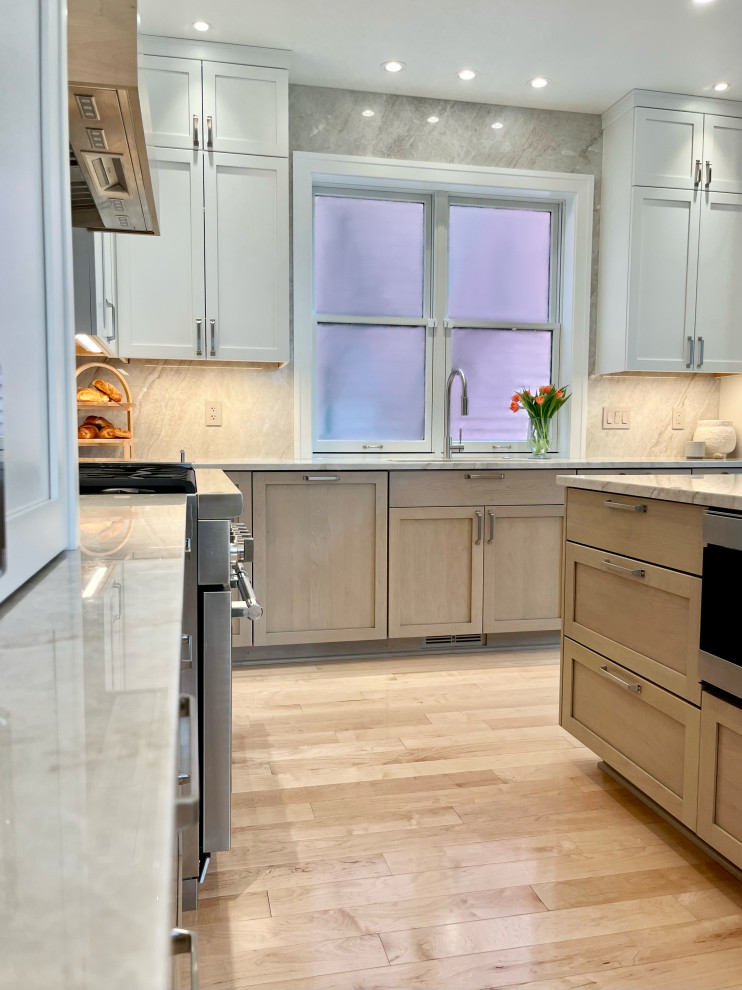 Eat-in kitchen - large modern l-shaped light wood floor and brown floor eat-in kitchen idea with an undermount sink, shaker cabinets, light wood cabinets, quartzite countertops, beige backsplash, stone slab backsplash, stainless steel appliances, an island and beige countertops